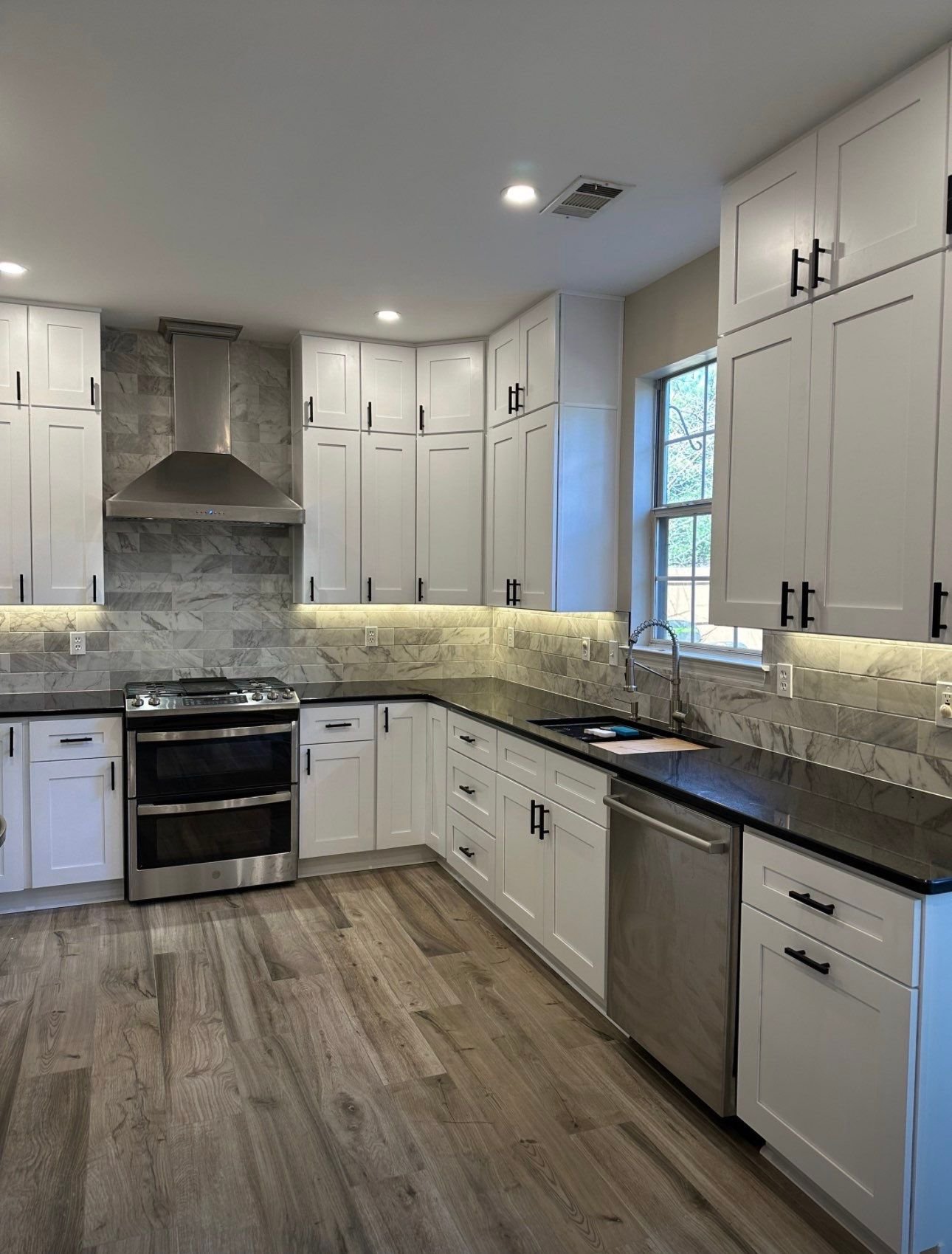Kitchen remodel with white shaker cabinets and black granite